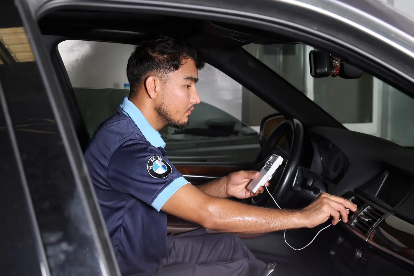 Technician inspecting dashboard electronics at Missak Auto Garage